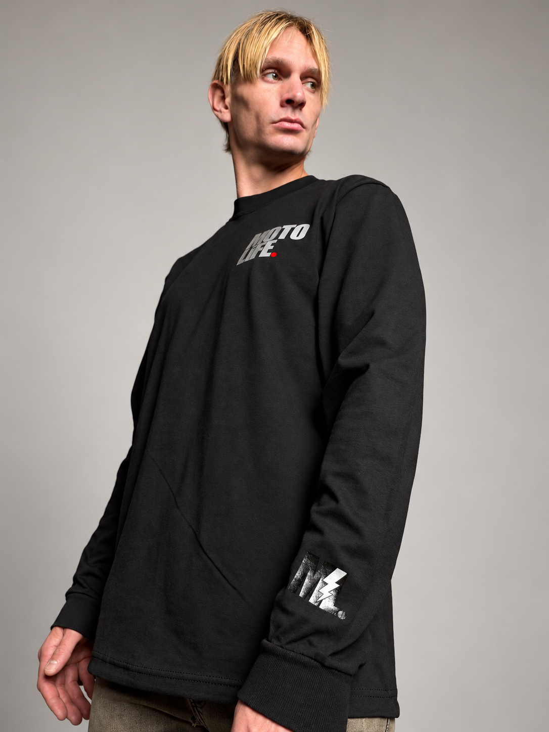 MOTOLiFE NiGHT SHiFT V2 black long sleeve T-shirt detail showing the reflective ML lightning mark, sleeve hem and cotton fabric texture.
